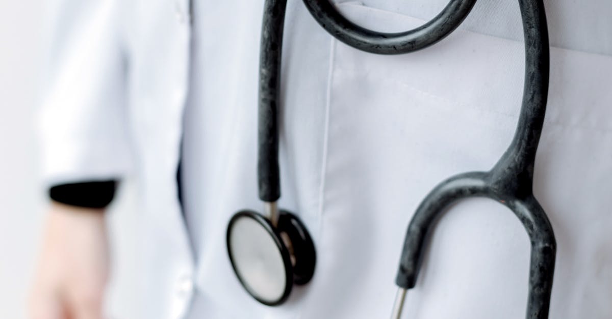 Close-up of a doctor holding a stethoscope, showcasing professional medical attire.